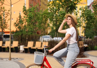 Young pretty woman riding bicycle in city. Space for text