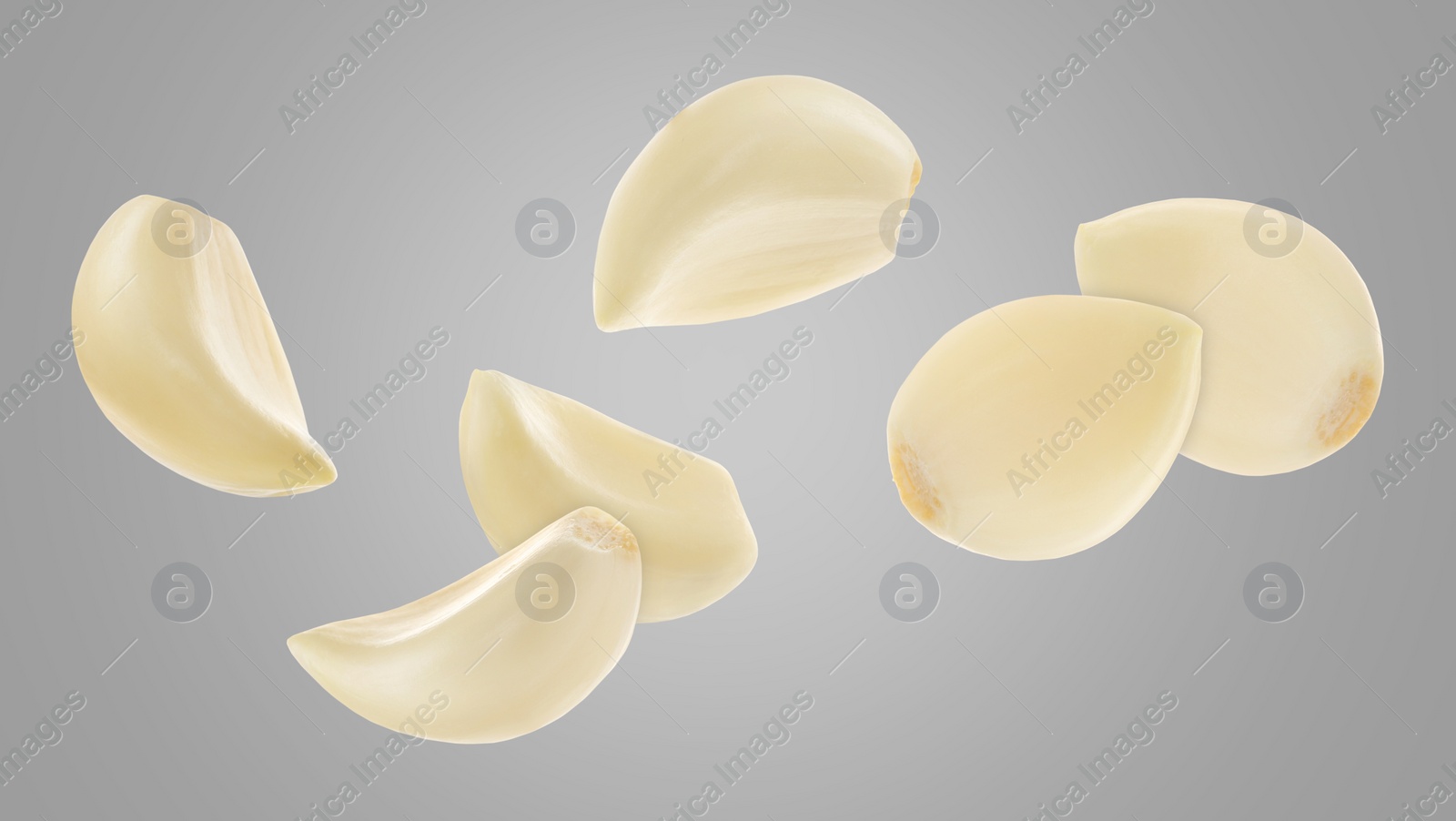 Image of Fresh garlic cloves falling on grey background, banner design