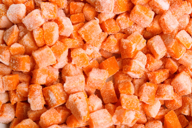 Photo of Tasty frozen carrots as background, top view. Vegetable preservation