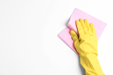 Photo of Person in rubber glove with rag on white background, closeup of hand