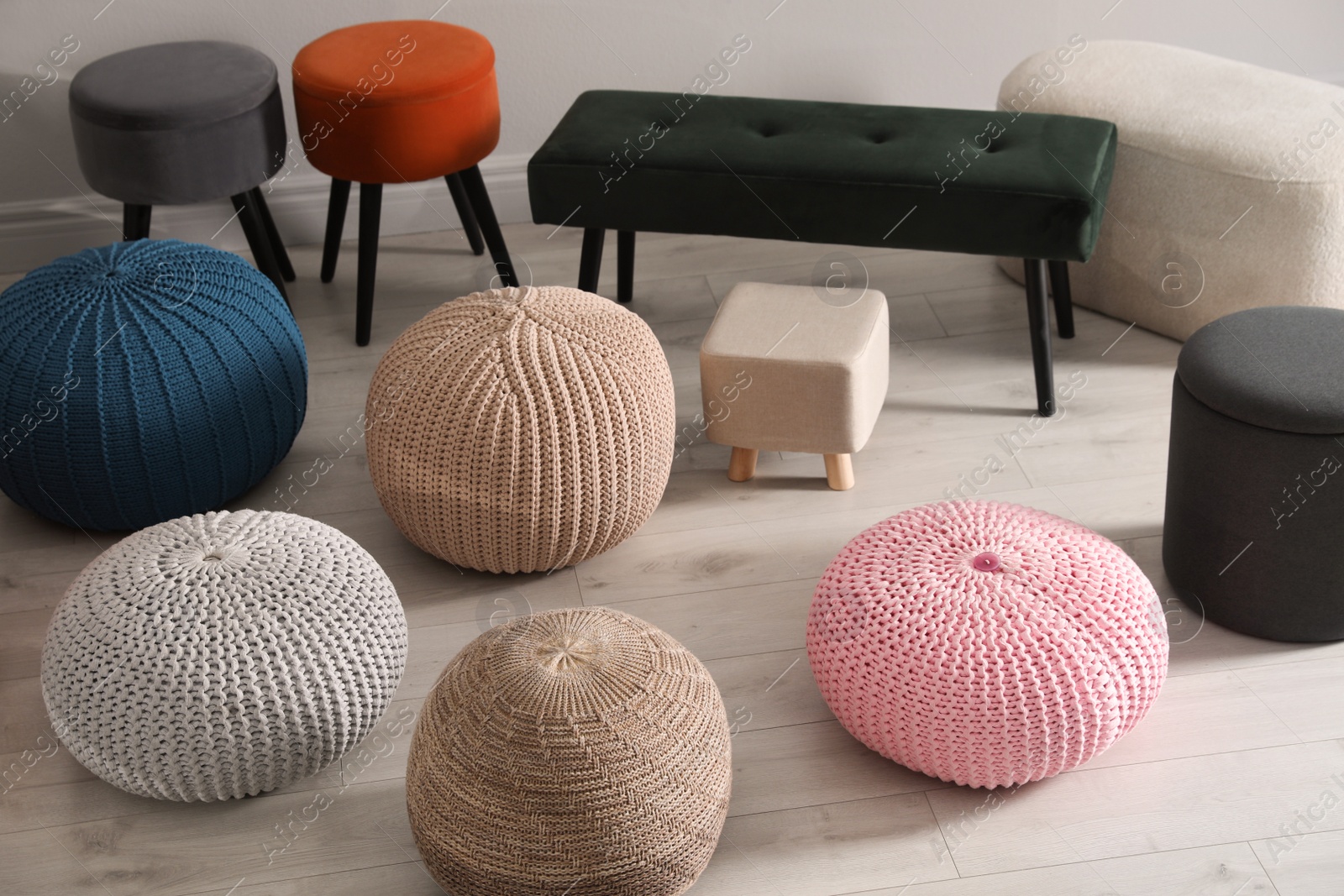 Photo of Many stylish different poufs and bench indoors. Home design