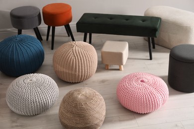 Photo of Many stylish different poufs and bench indoors. Home design