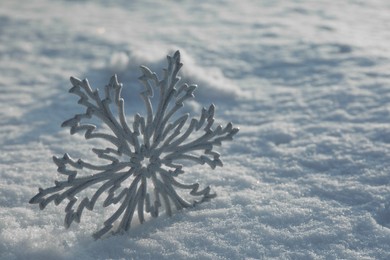 Beautiful decorative snowflake in white snow, outdoors. Space for text