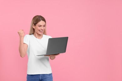 Photo of Emotional woman with laptop on pink background. Space for text