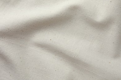 Photo of Texture of beige crumpled fabric as background, top view