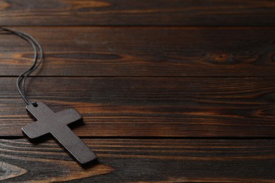 Photo of Wooden Christian cross on table, space for text