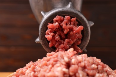 Photo of Manual meat grinder with beef mince against blurred background, closeup