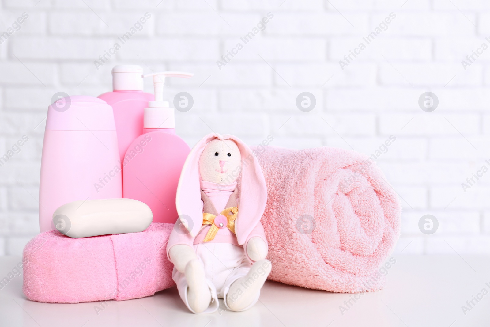 Photo of Baby accessories on table near white brick wall