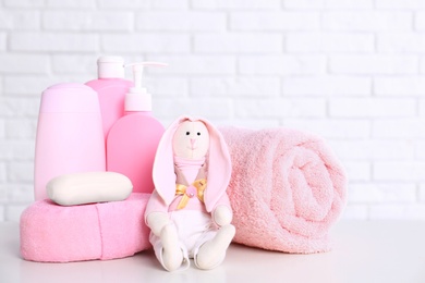 Baby accessories on table near white brick wall