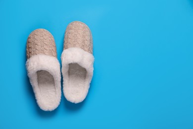 Photo of Pair of beautiful soft slippers on light blue background, top view. Space for text