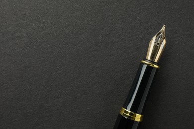 Photo of Stylish fountain pen on black background, top view. Space for text