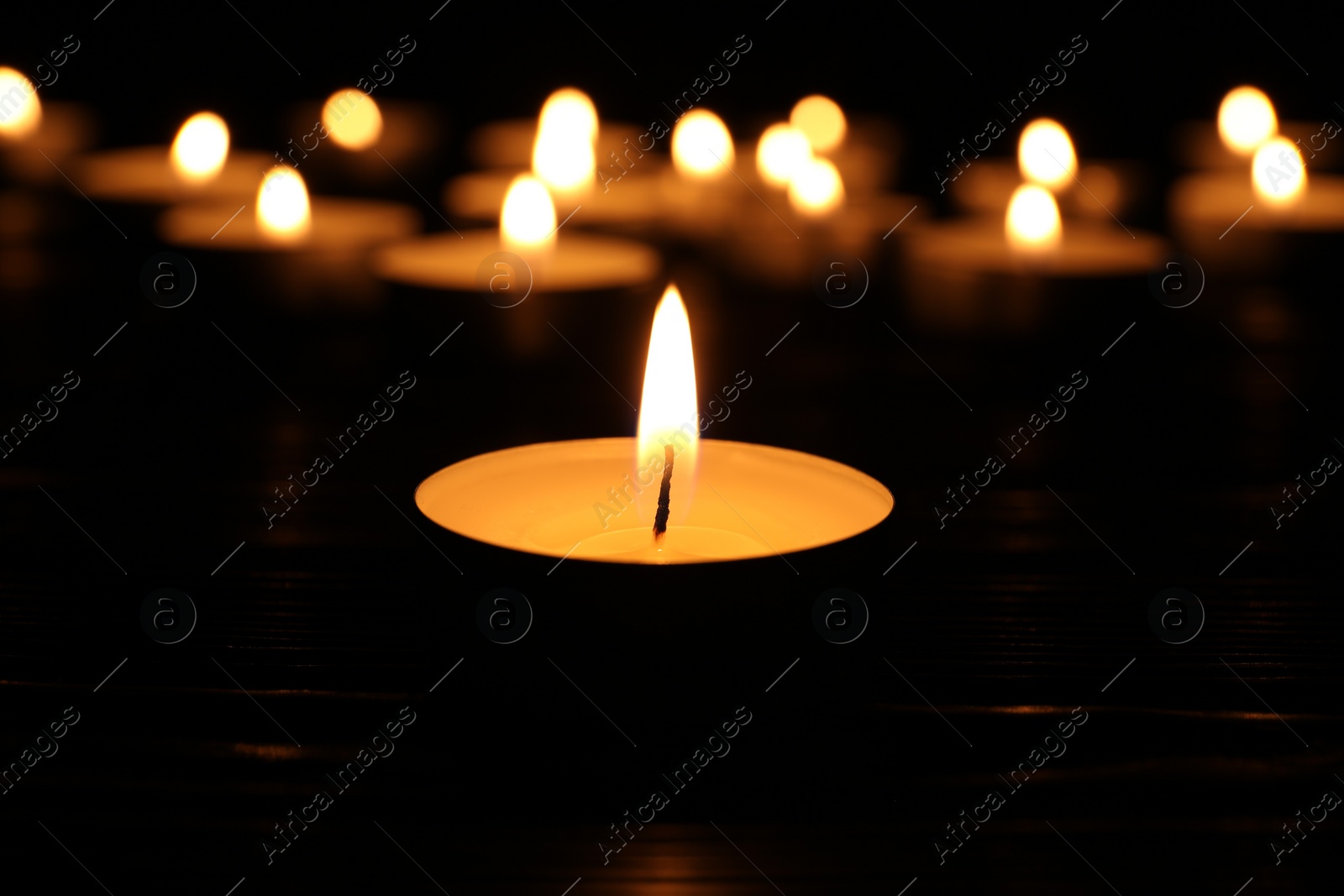 Photo of Burning candle in darkness, closeup. Memory day