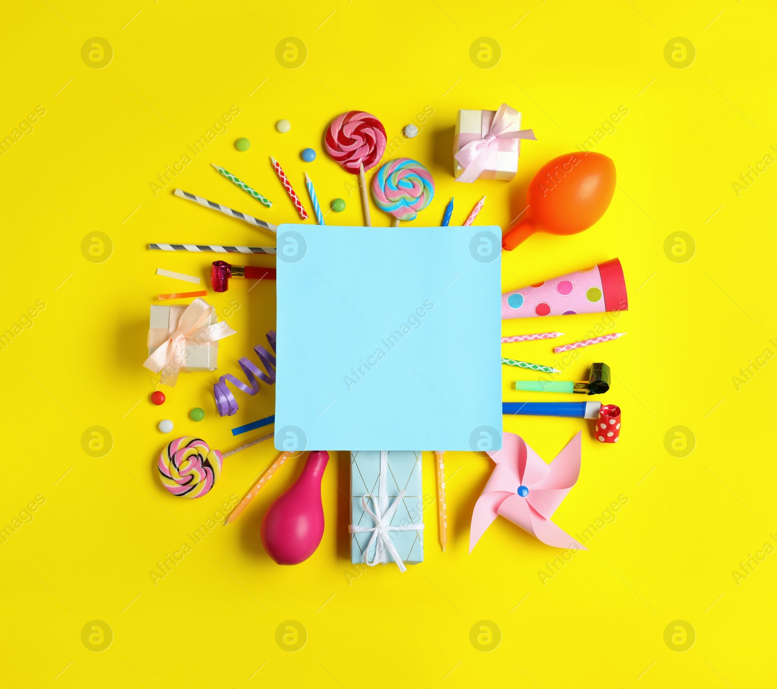 Photo of Different birthday party items and blank card on yellow background, flat lay. Space for text