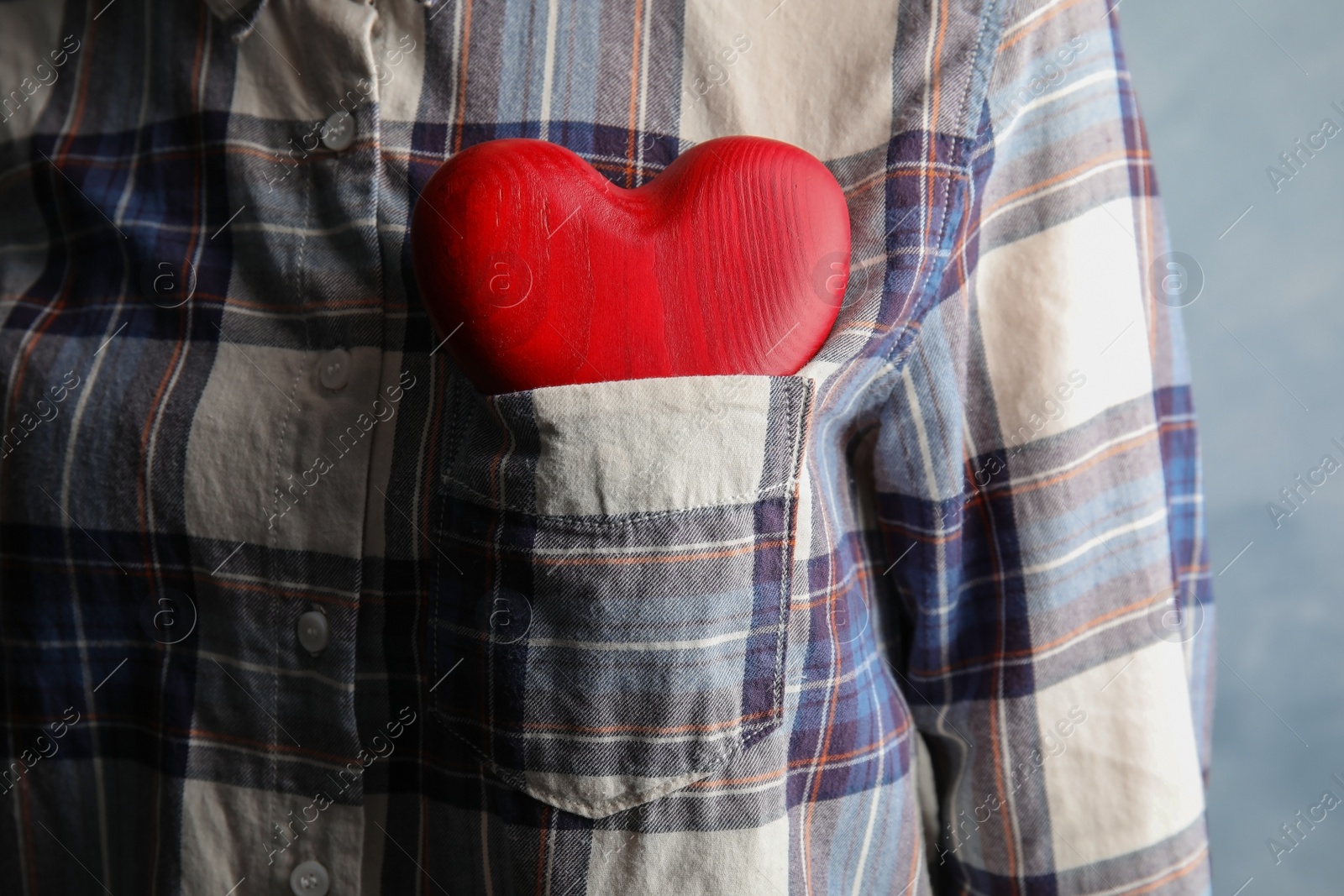 Photo of Woman with red heart in pocket, closeup. Helping and supporting concept