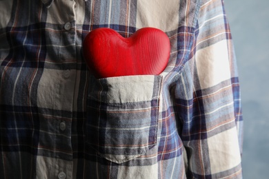 Photo of Woman with red heart in pocket, closeup. Helping and supporting concept