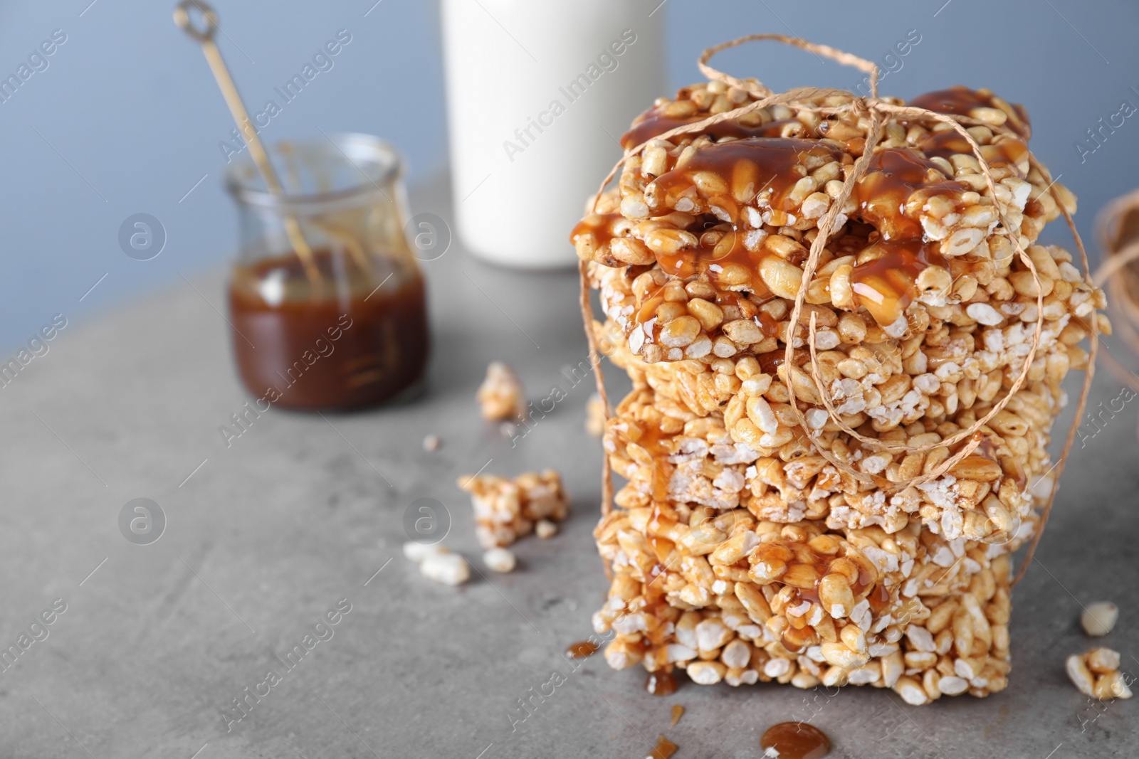 Photo of Delicious rice crispy treats on grey table. Space for text