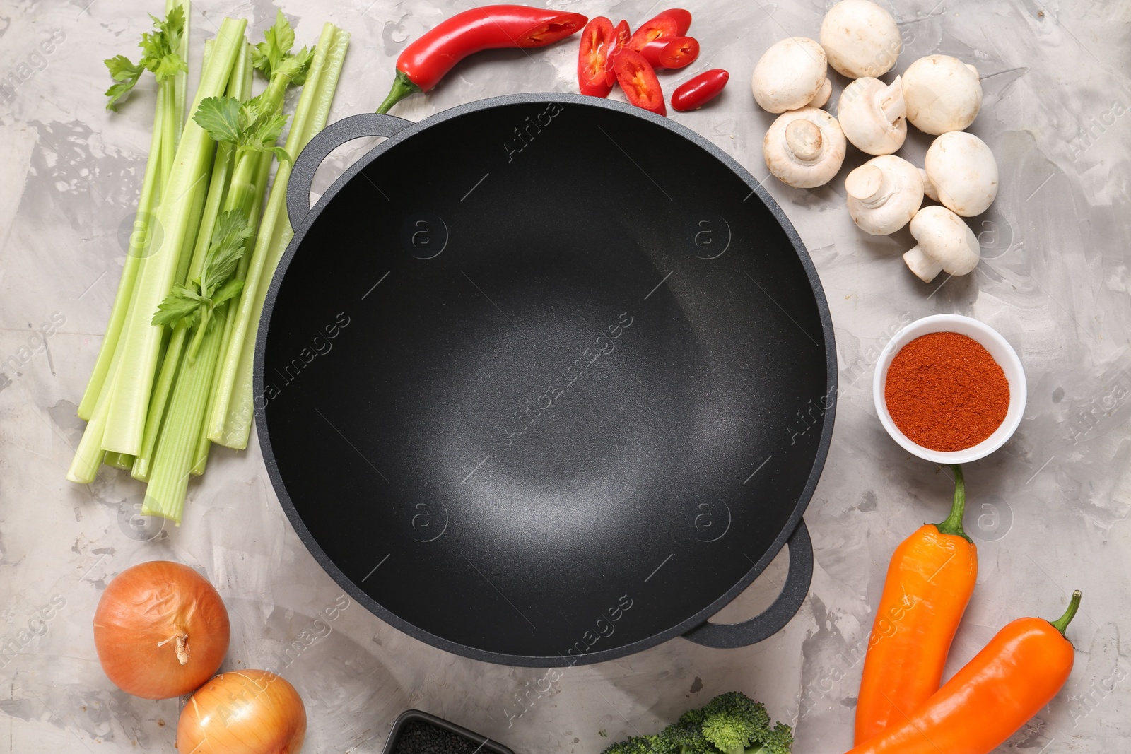 Photo of Wok and different products on grey textured table, flat lay