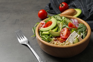 Photo of Delicious avocado salad with quinoa on grey table