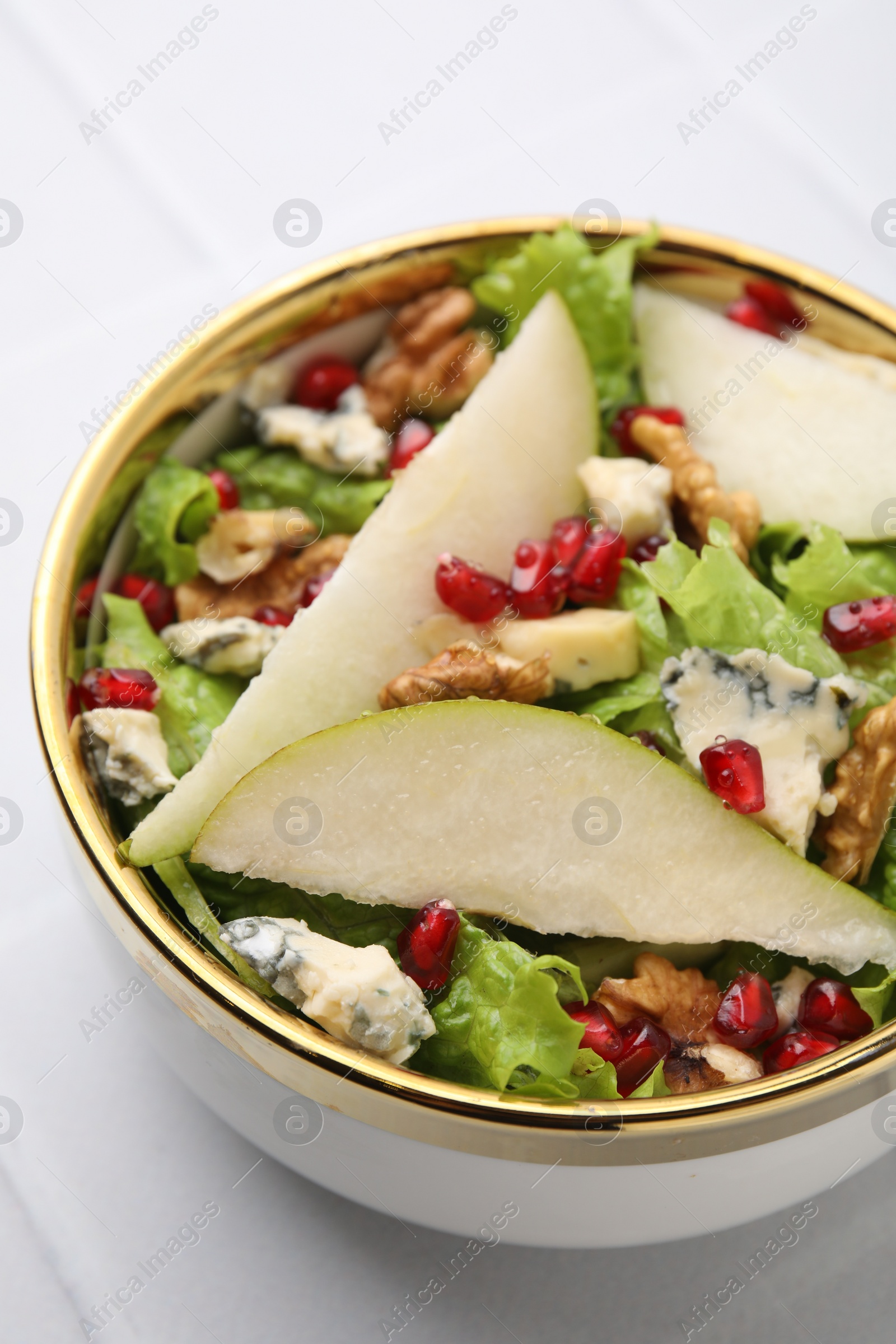 Photo of Delicious pear salad in bowl on light table, closeup