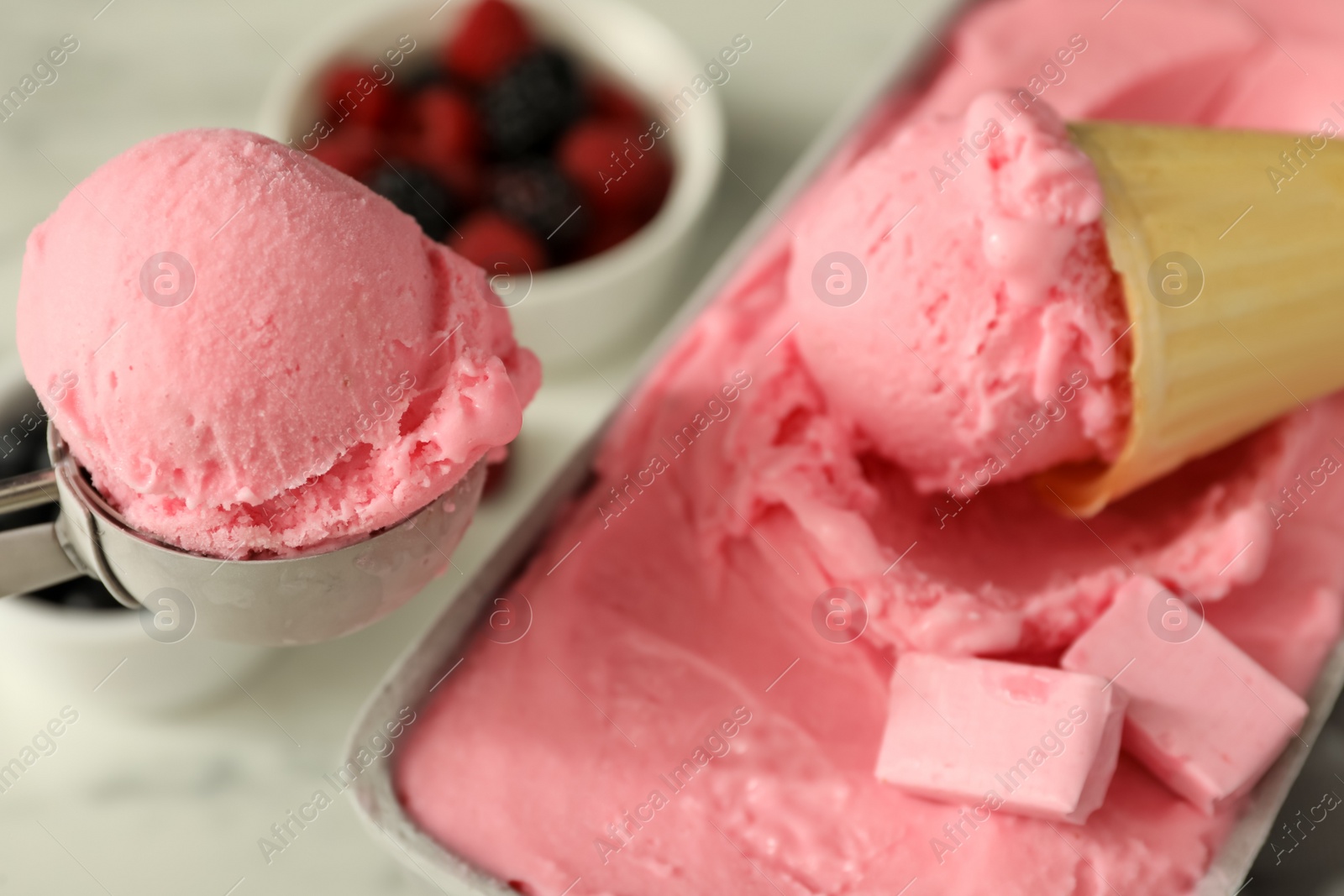 Photo of Delicious ice cream in container and wafer cone on table, closeup