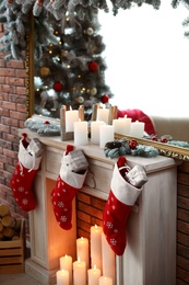 Decorative fireplace with Christmas stocking and gifts in stylish room interior