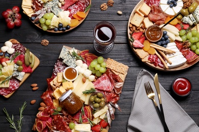 Assorted appetizers served on black wooden table, flat lay