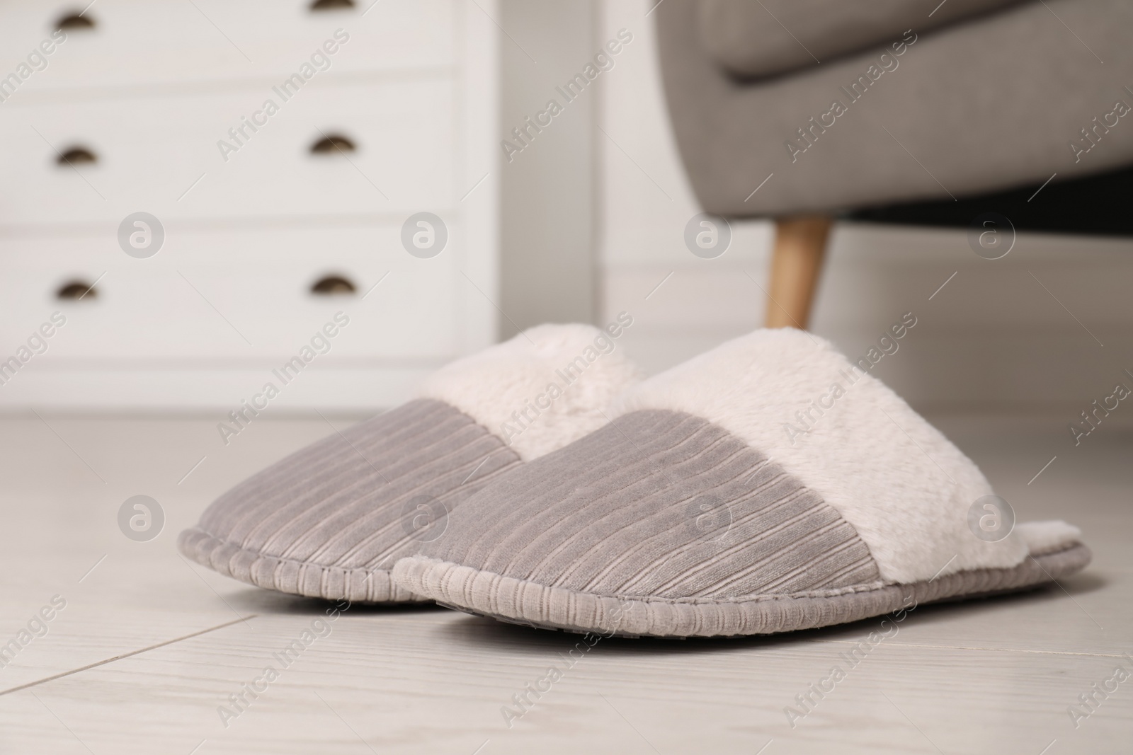 Photo of Grey warm slippers on floor in room