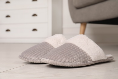 Photo of Grey warm slippers on floor in room