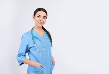 Photo of Portrait of medical assistant with stethoscope on light background. Space for text