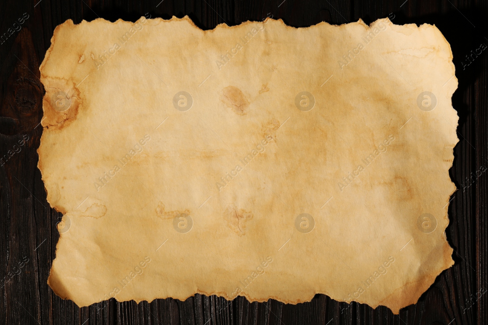 Photo of Sheet of old parchment paper on wooden table, top view