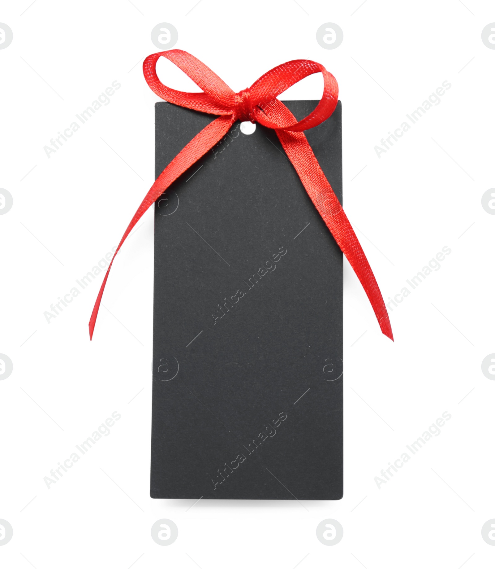 Photo of Blank black gift tag with red satin ribbon on white background, top view. Space for design