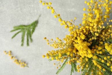 Photo of Bouquet of beautiful mimosa flowers on grey table