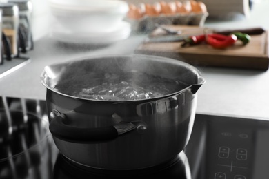 Pot with boiling water on electric stove in kitchen