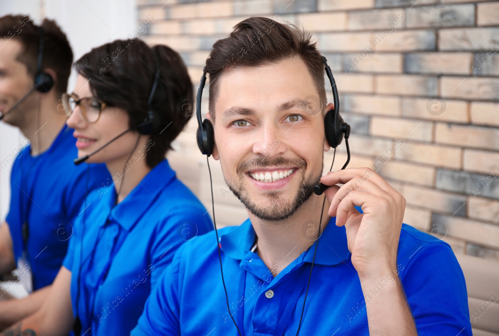 Photo of Technical support operators with headsets at workplace