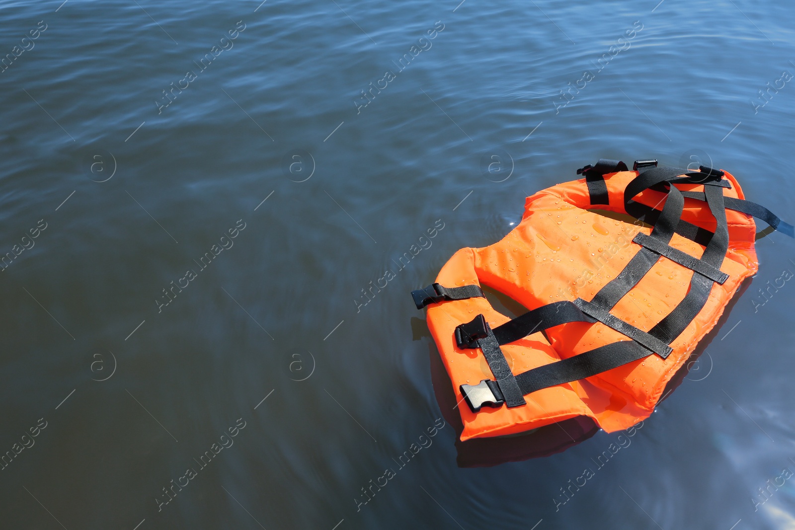 Photo of Orange life jacket floating in sea. Emergency rescue equipment