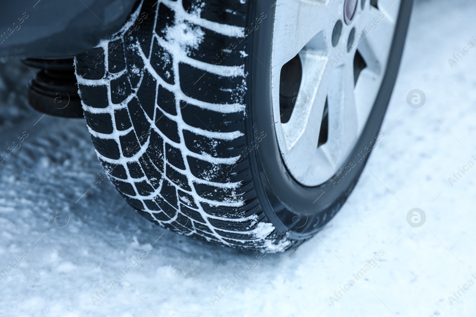 Photo of Car with winter tires on snowy road, closeup view