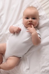 Photo of Cute little baby lying on bed, top view