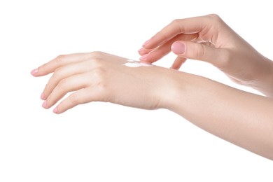 Photo of Woman applying cream on her hand against white background, closeup