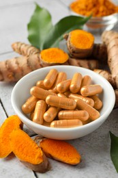 Photo of Turmeric roots and pills on light table, closeup