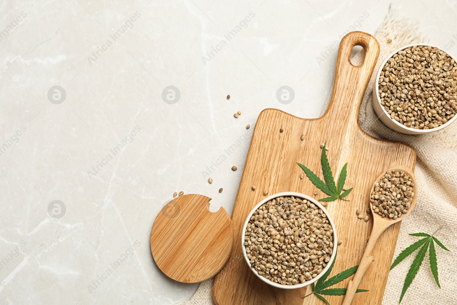 Photo of Flat lay composition with hemp seeds and leaves on beige marble background, flat lay. Space for text