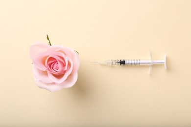 Photo of Cosmetology. Medical syringe and rose flower on yellow background, flat lay