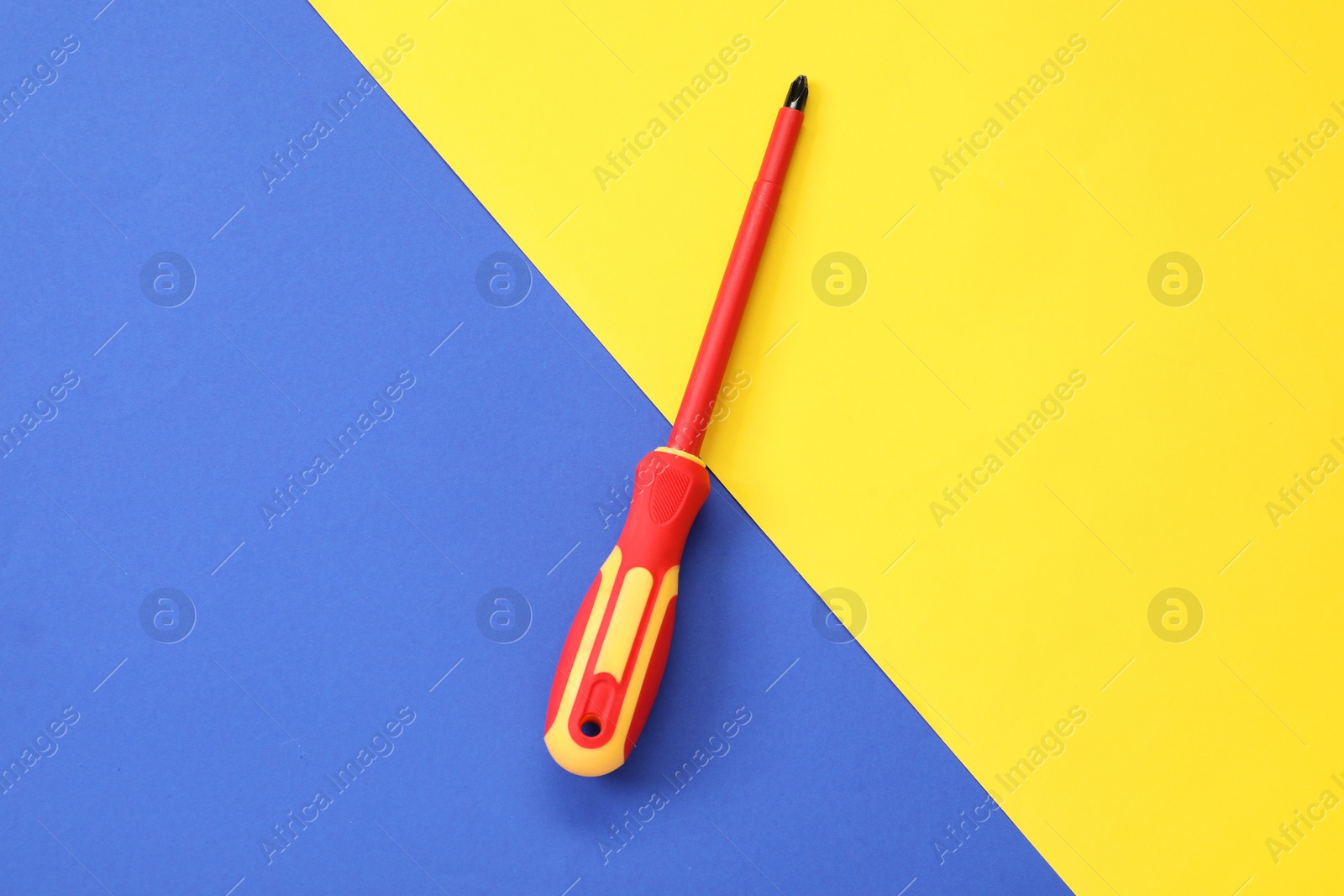 Photo of Screwdriver with red handle on color background, top view