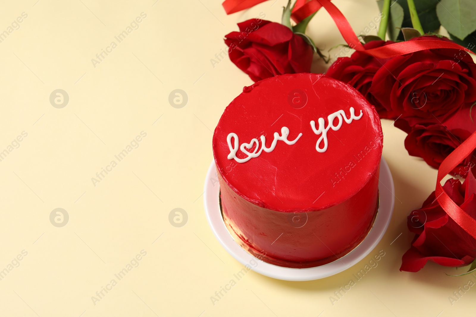 Photo of Bento cake with text Love You and red roses on beige table, space for text. St. Valentine's day surprise