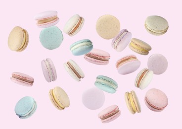 Image of Sweet delicious macarons flying on pink background