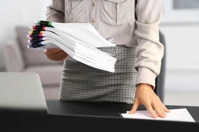 Photo of Businesswoman with documents near dark table in office, closeup
