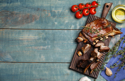 Photo of Delicious roasted ribs served on light blue wooden table, flat lay. Space for text