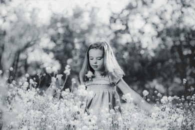 Cute little girl outdoors on sunny day. Black and white effect