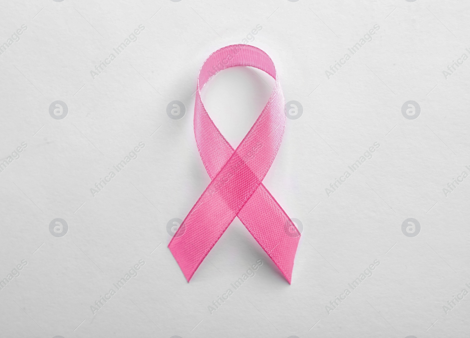 Photo of Pink ribbon on white background, top view. Breast cancer awareness concept