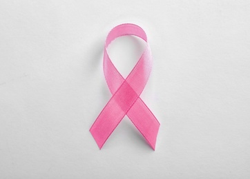 Pink ribbon on white background, top view. Breast cancer awareness concept