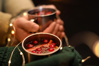 Photo of Couple with cups of tasty mulled wine, closeup